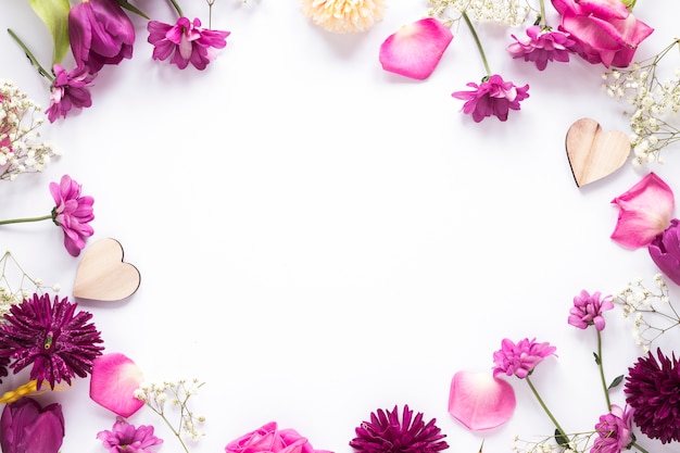 Photo different flowers with wooden hearts on table