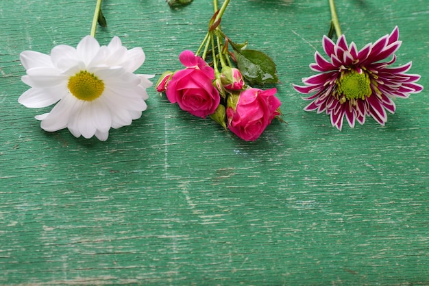 Different flowers on wooden background