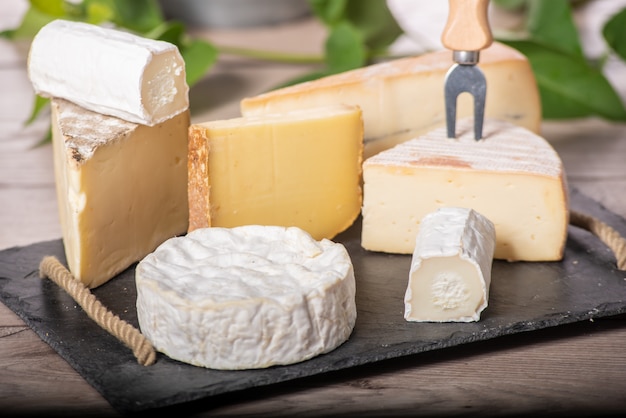 Photo different french cheeses on slate plate