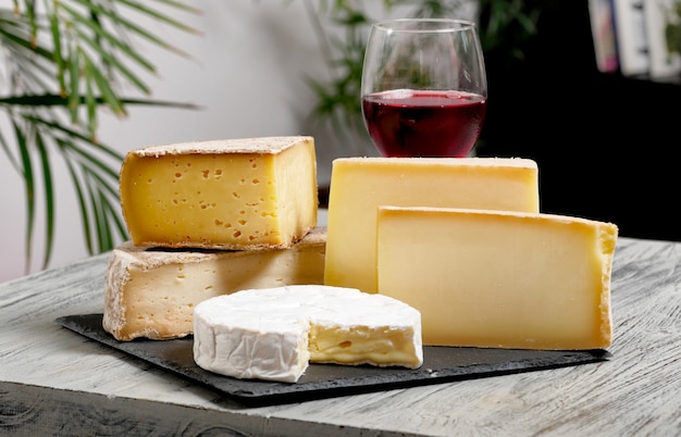 Different french cheeses with a glass of wine