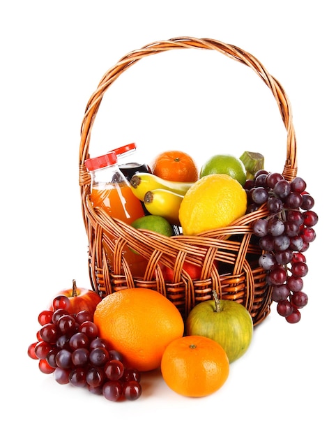 Different fruits in wicker basket with juice isolated on white