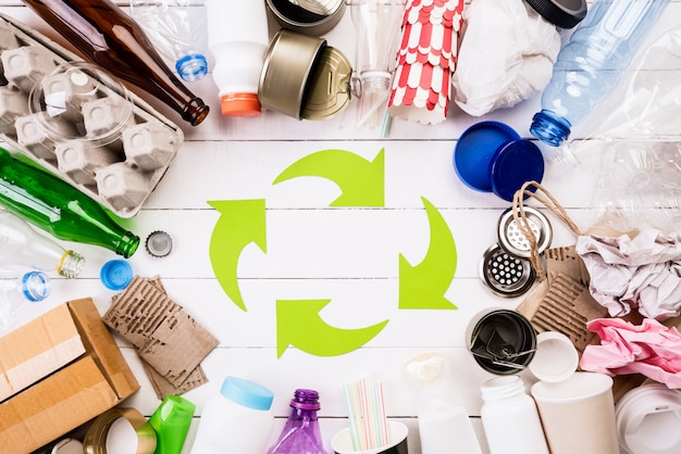 Photo different garbage materials with recycling symbol