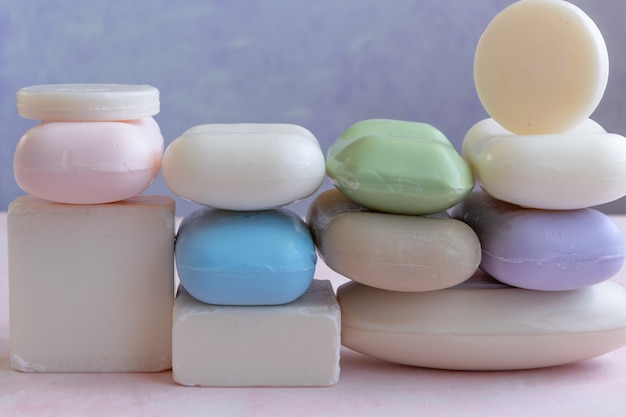 Different handmade  bar soaps on pink background. Hygiene, artisanal products