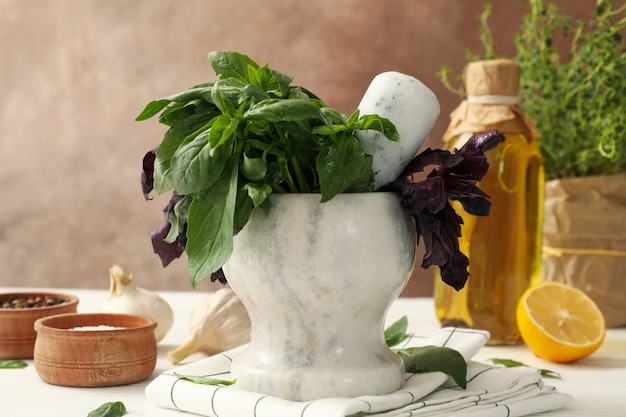 Different herbs, oil and spices on white wooden table