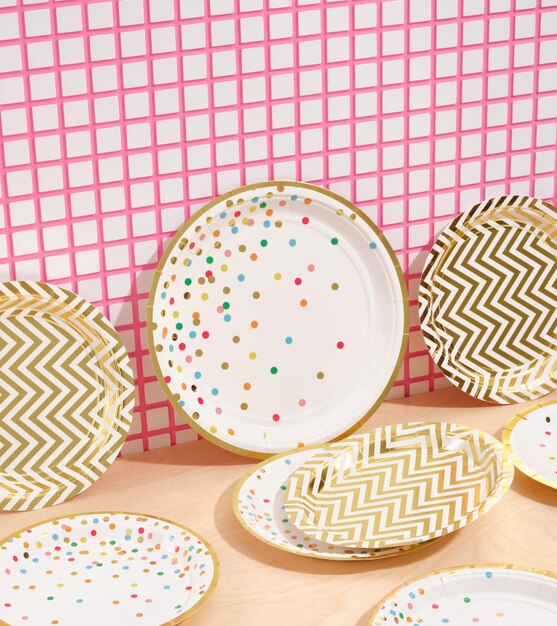 Различные праздничные тарелки с конфетти и другим креативным дизайном на десертном столе Красочное украшение с днем рождения