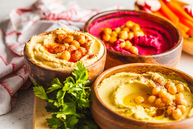 Different hummus bowls. Chickpea hummus, avocado hummus and beetroot hummus.