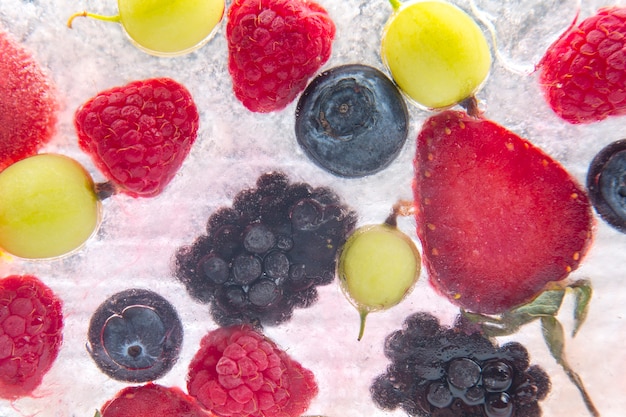 Different juicy berries frozen in ice. useful vitamin healthy food fruit