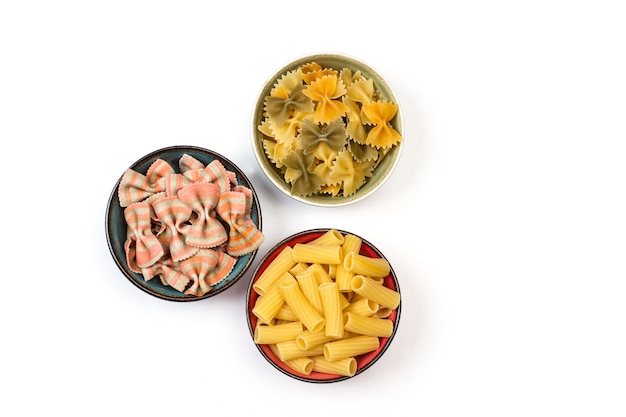 Different kind of pasta in colored bowls in an isolated view