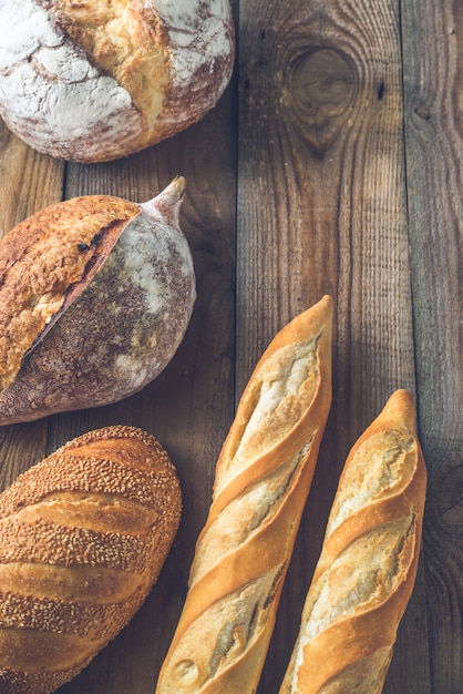 Different kinds of bread on the wooden surface