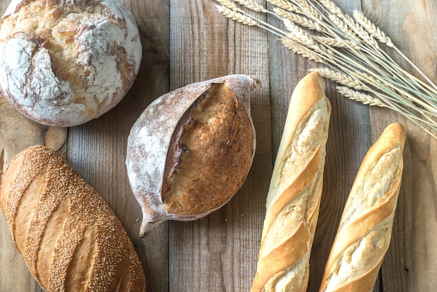 Different kinds of bread on the wooden surface