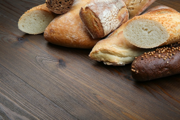 Different kinds of bread on wooden table