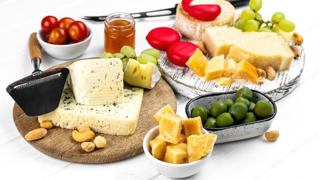 Different kinds of cheese served with green olives tomato and grape for gourmet nutrition organic pa