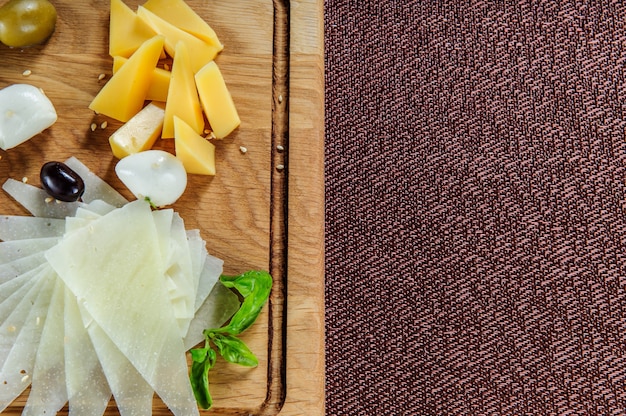 Different kinds of cheese on wooden background