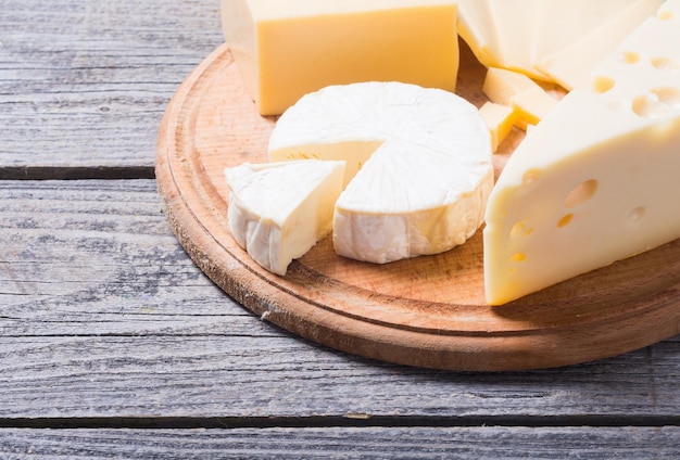 different kinds of cheese on wooden background