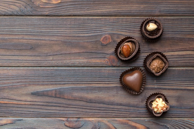 Diversi tipi di cioccolatini sul tavolo colorato in primo piano top view e flat lay con spazio per la copia