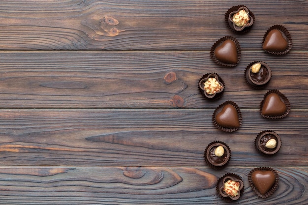 Diversi tipi di cioccolatini sul tavolo colorato in primo piano top view e flat lay con spazio per la copia