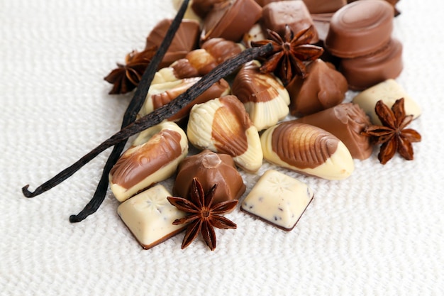 Different kinds of chocolates with spices on white background