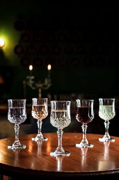 Различные виды напитков в старинных бокалах для коктейлей в баре