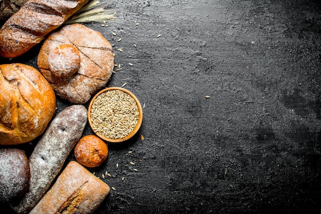 Different kinds of fresh bread with grain in bowl