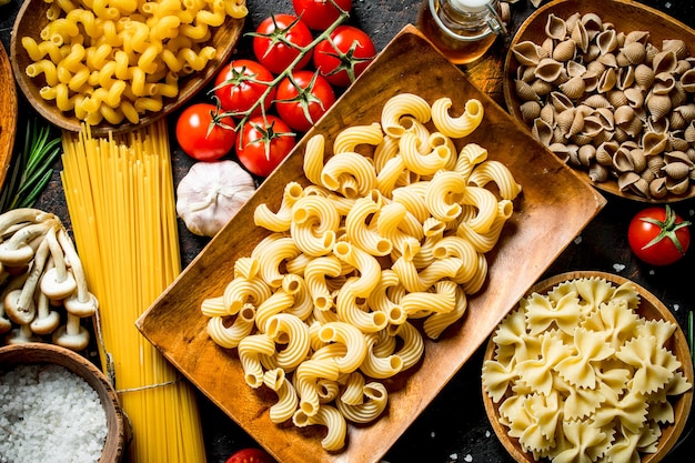 Different kinds of raw paste in bowls with garlic mushrooms and cherry