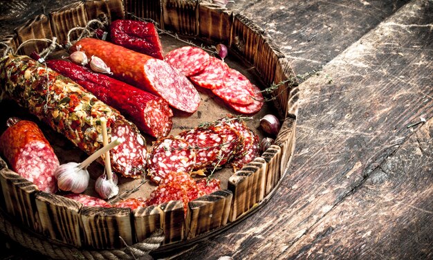 Different kinds of salami on the boards. On a wooden table.