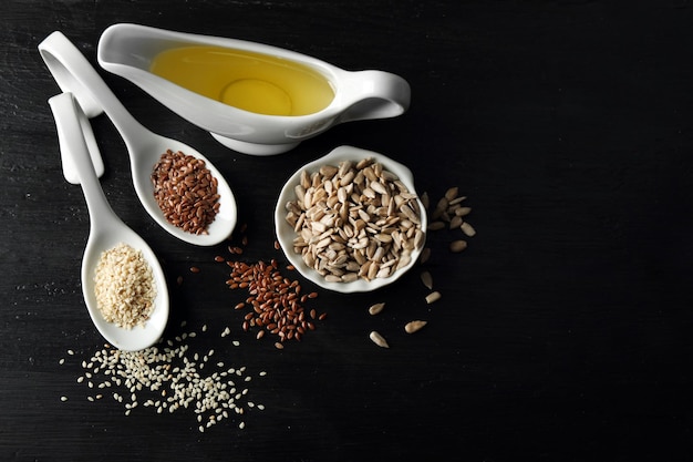 Different kinds of seeds and oil on wooden table