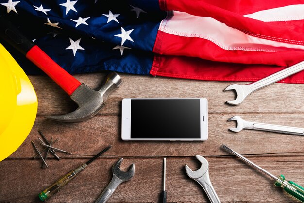 Different kinds wrenches, American flag and smartphone blank screen