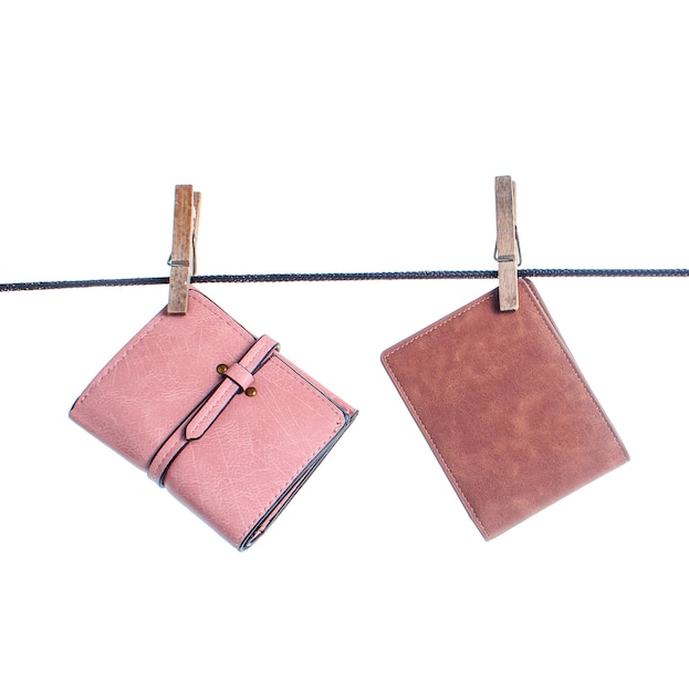 Different leather wallets are hanging on the clothesline with the buckles Isolated