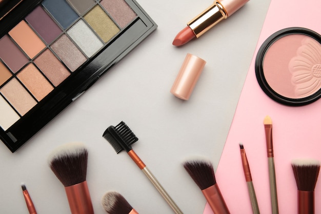 Different luxury makeup products on colorful background, flat lay. Top view