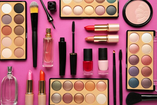Различные роскошные косметические продукты на розовом фоне, плоская планировка. вид сверху