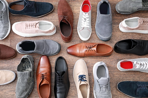 Different male shoes on wooden floor