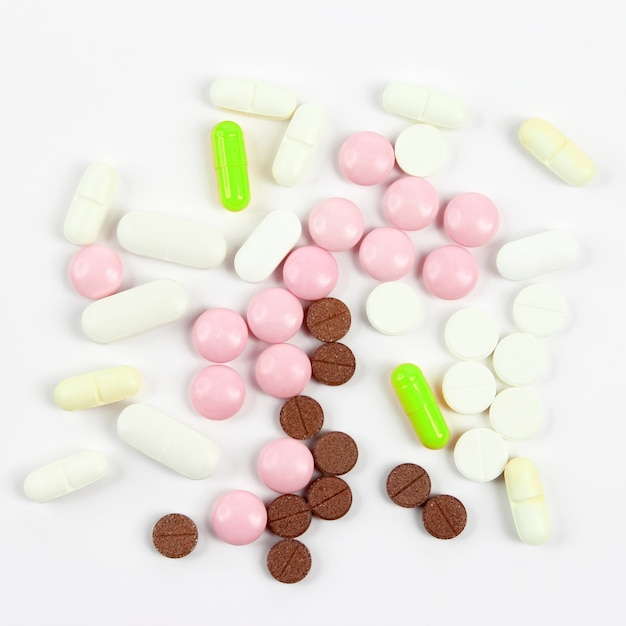 Различные лекарственные таблетки на белом фоне. фармакология и медицинская промышленность