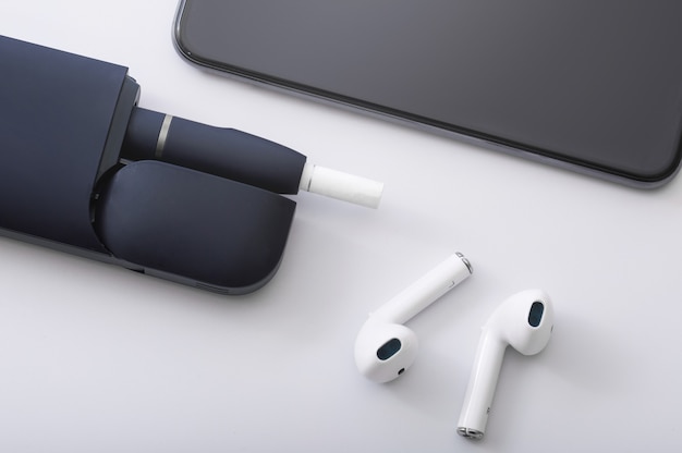 Different modern electronic devices - Tobacco heating system, wireless earphones and smartphone