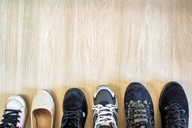 Different modern fashionable shoes on wooden background.