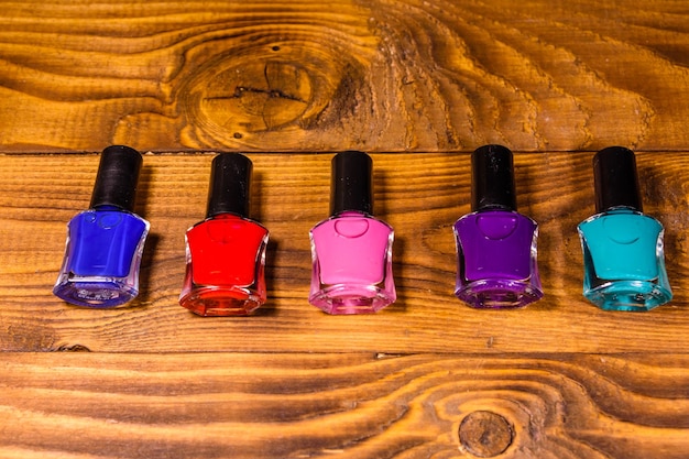 Different nail polishes on rustic wooden table