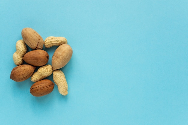 Different nuts on a blue background with copy space