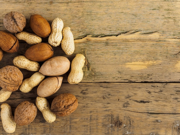 Different nuts on the wooden surface