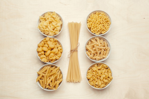 Different pasta types in bowls on the table