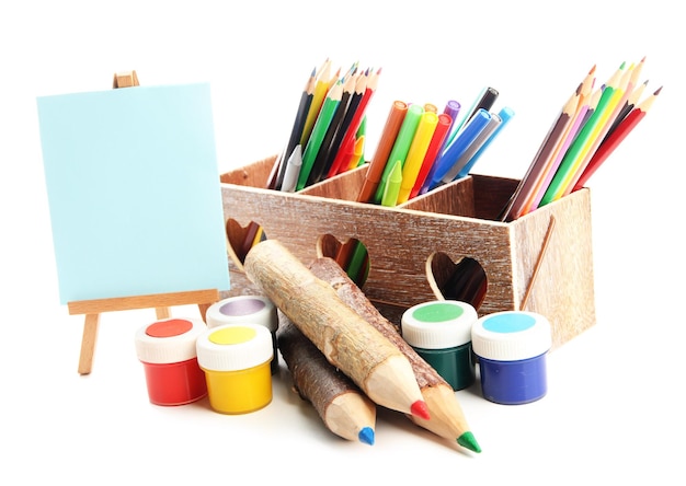 Photo different pencils in wooden crate paints and easel isolated on white