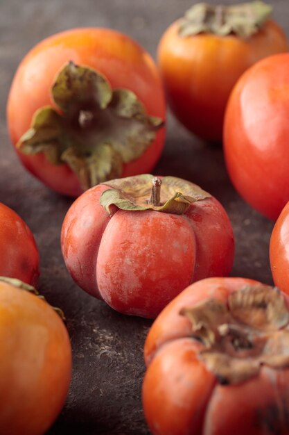 Different persimmons on a dark background