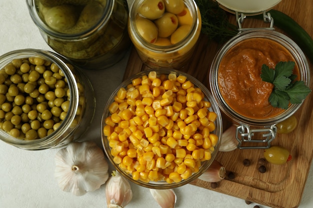 Different pickled food and ingredients on white textured wall