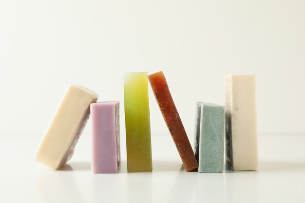 Different pieces of natural soap on white background