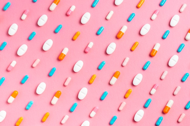 Different pills on pink background