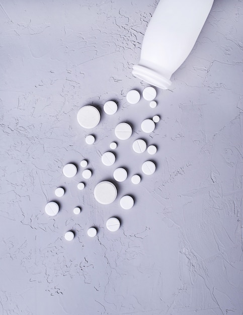 Different pills and tablets on grey background