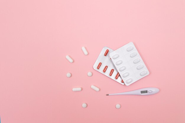 Упаковка различных таблеток и таблеток с белым электронным термометром