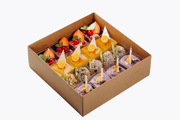 Different portions of desserts with jelly and fruit in a box are ready for delivery