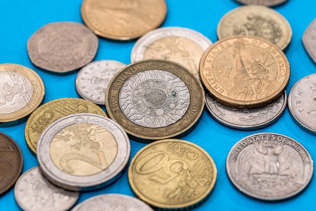 Different Pound coins on a blue surface.