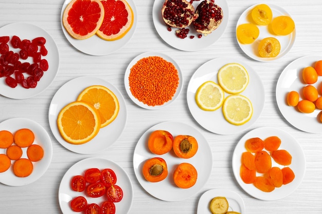 Different products on saucers on wooden table top view