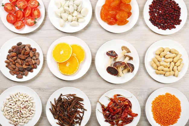 Different products on saucers on wooden table top view