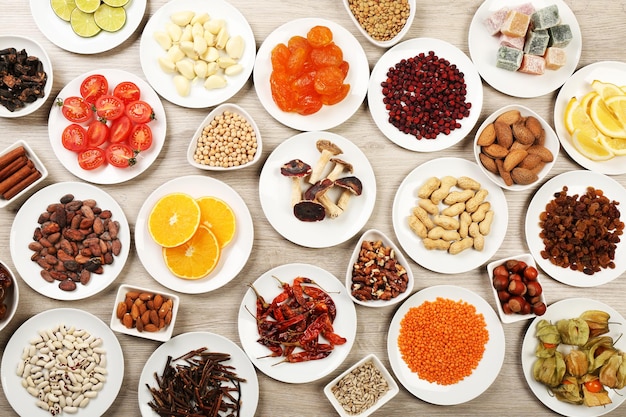 Different products on saucers on wooden table top view